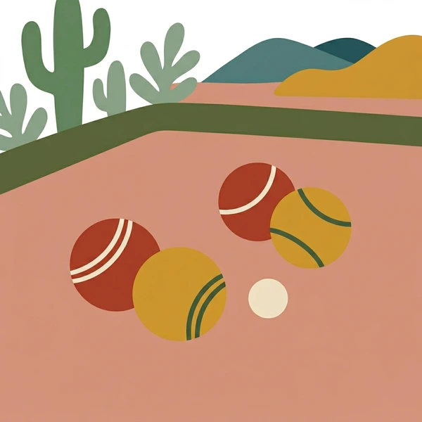 Red and yellow bocce balls with a white pallino resting on tan gravel in a desert setting with green cacti and sandy sand dunes in the background